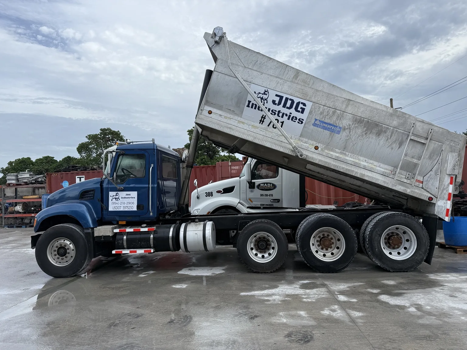 JDG blue dump truck with its bed raised